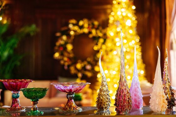 Glass blown whimsical trees and candy dishes displayed on a table top.